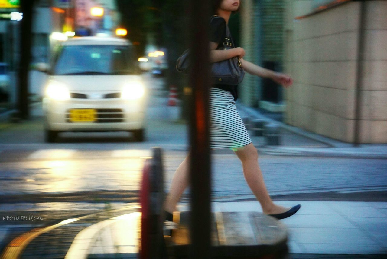 BLURRED MOTION OF WOMAN WALKING IN CITY