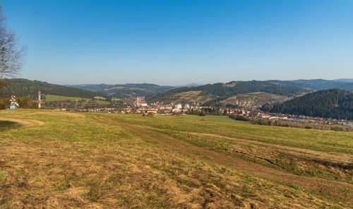 Scenic view of field and mountains against clear sky