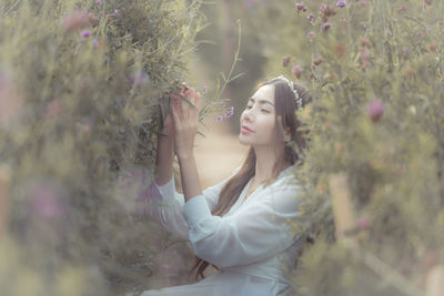 Young woman with pink flower in garden