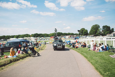 People sitting on road against sky