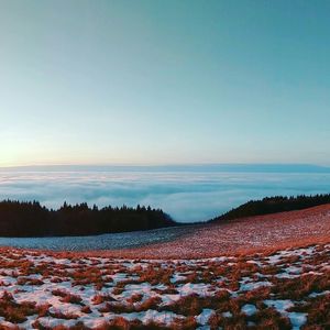 Scenic view of snow covered land against sky