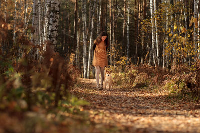 Man standing by trees in forest