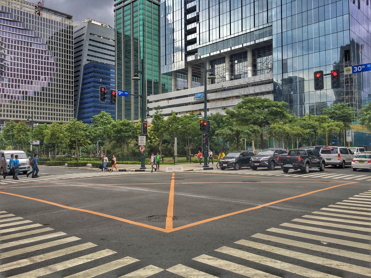 building exterior, city, architecture, built structure, street, road marking, city life, road, land vehicle, city street, office building, skyscraper, mode of transport, modern, building, traffic, tall - high, day, outdoors, capital cities, sky, travel destinations, the way forward