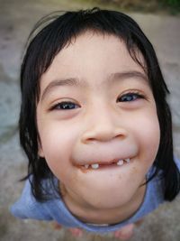 Close-up portrait of girl making face while standing on field