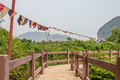 Prayer flags waving above footbridge