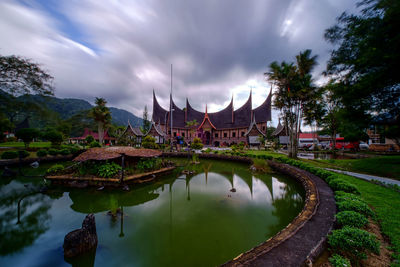 Panoramic view of canal against cloudy sky