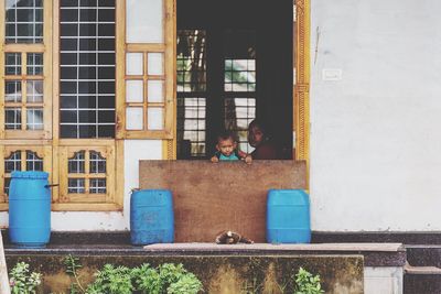 Portrait of two people sitting outside building