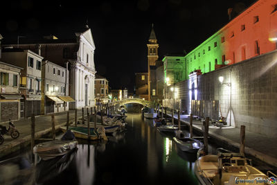 Boats moored in canal at night