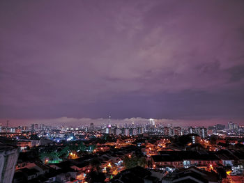 High angle view of illuminated city against sky at dusk