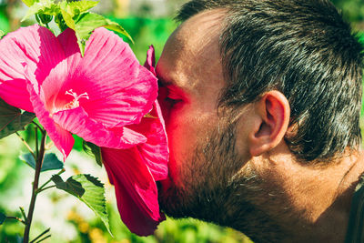 Close-up of woman with pink flower