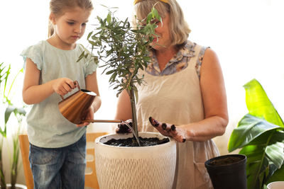 Portrait of smiling woman holding plant