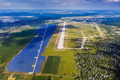 Top view of the power plant with solar panels and the aerodrome. beautiful green fields, blue sky.