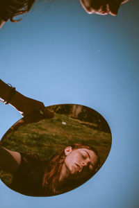 Portrait of smiling woman against clear blue sky