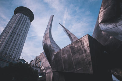 Low angle view of buildings against cloudy sky