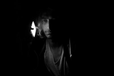 Close-up portrait of young man in darkroom