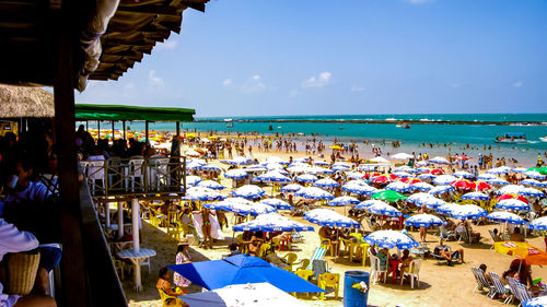 Group of people on beach against sky