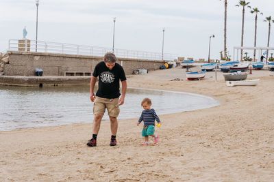 Father and child walking along the beach