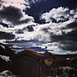 Buildings in town against cloudy sky