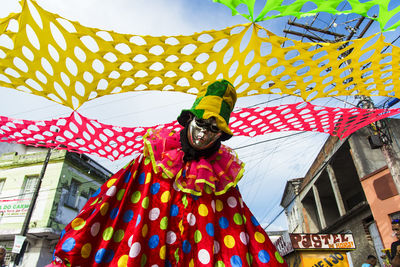 Person seated wearing carnival mask