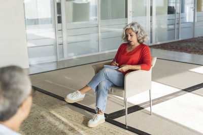 Senior businesswoman discussing with colleague in office