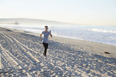 Full length of woman jogging at beach