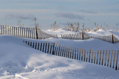 Panoramic view of snow covered field against sky