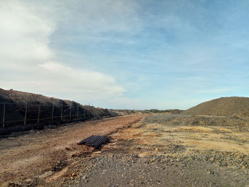 Road amidst field against sky