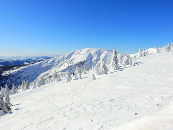 Scenic view of snowcapped mountains against clear blue sky