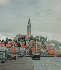 Buildings in city against cloudy sky