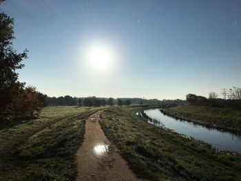 Scenic view of river amidst field against sky