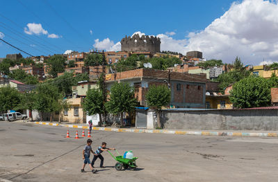 People on street against buildings in city