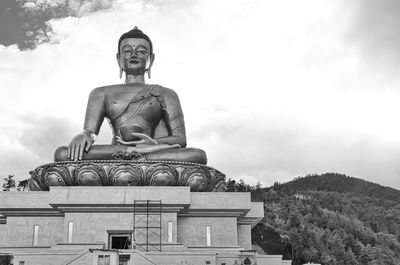 Low angle view of statue against building against sky