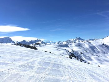 Scenic view of snowcapped mountains against blue sky