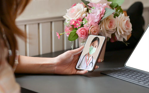 Close-up of woman using mobile phone on table