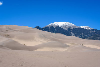 Scenic view of snowcapped mountains against clear blue sky