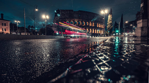 Illuminated city street during rainy season at night