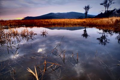 Scenic view of lake against sky at sunset