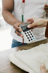 Hand of customer paying through credit card at store