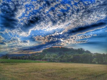 Scenic view of grassy field against dramatic sky