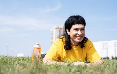 Portrait of smiling boy on grassy field against sky