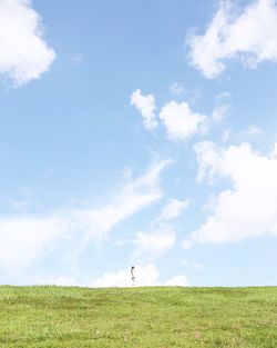 Scenic view of grassy field against cloudy sky