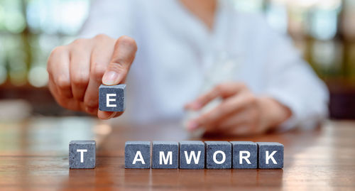 Midsection of person holding smart phone on table