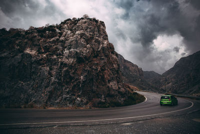 Road amidst rocks and mountains against sky