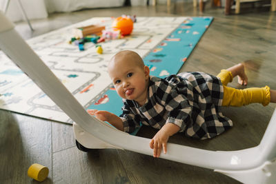 Cute baby girl playing with a toy on a play mat.