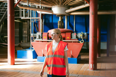 Woman in reflective clothing standing at factory