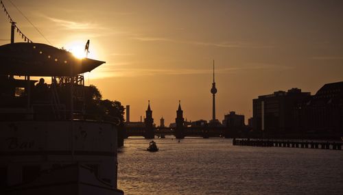 Communications tower in city at sunset