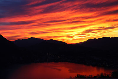 Scenic view of silhouette mountains against orange sky