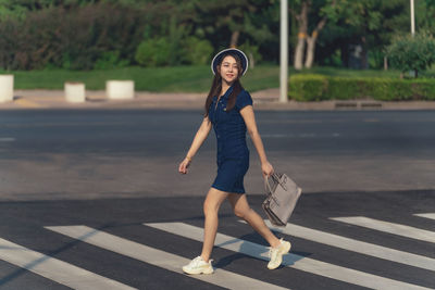 Full length of woman exercising on road