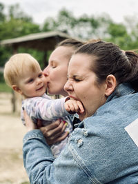 Side view of mother carrying daughter