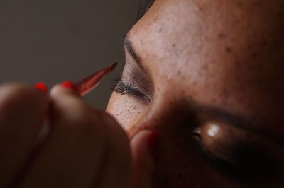 Close-up of young woman doing make-up